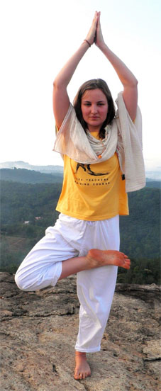 Luna praktiziert auf einem Felsen Vrikshasana
